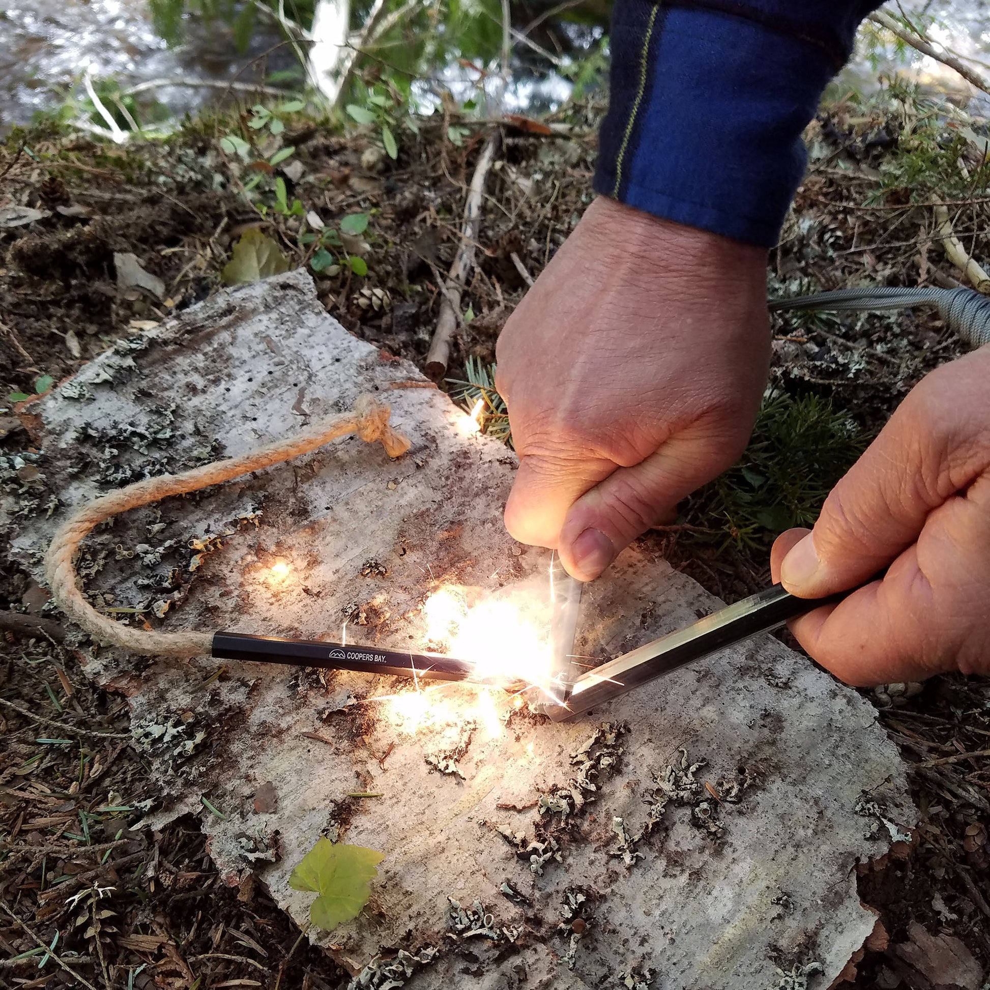 The Hexalite ferro rod striking white hot sparks onto a tinder FireWick to start a fire..