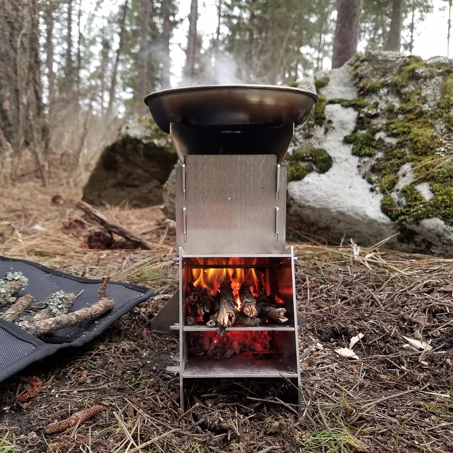 This flat packing twig rocket stove is great for camping, hiking, backpacking, hunting and wilderness survival. This stove uses twigs for fuel and cooks food and boil water quickly. Made from stainless steel, this portable stove can be set up within minute and boiling water in less than 3 minutes. Includes a super tough carrying case made from 1680d ballistic nylon.